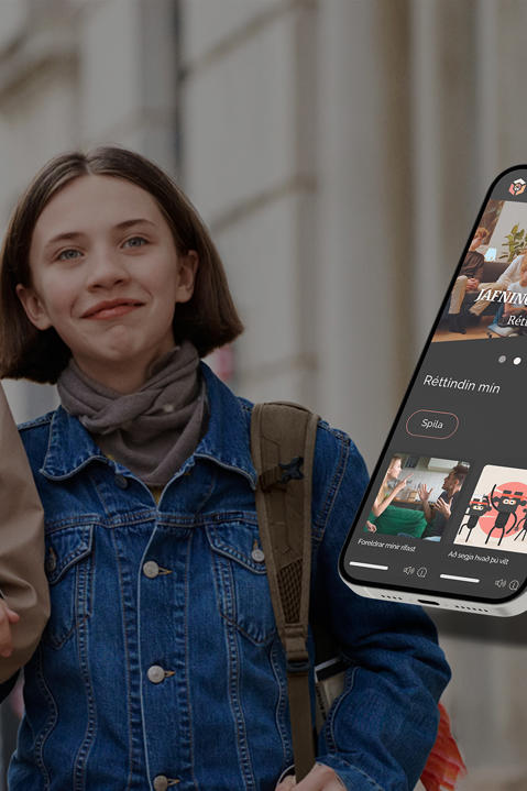 A woman and young lady walk hand in hand down a street with a smart phone showing SES Family content imposed on the foreground